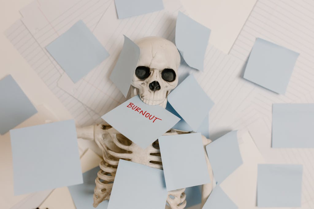 A skeleton covered in sticky notes with 'burnout' on one, symbolizing work stress and exhaustion.