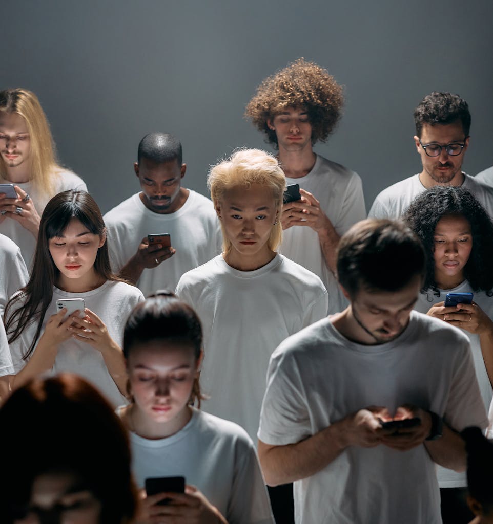 Diverse group of adults focused on smartphones, depicting social disconnection.