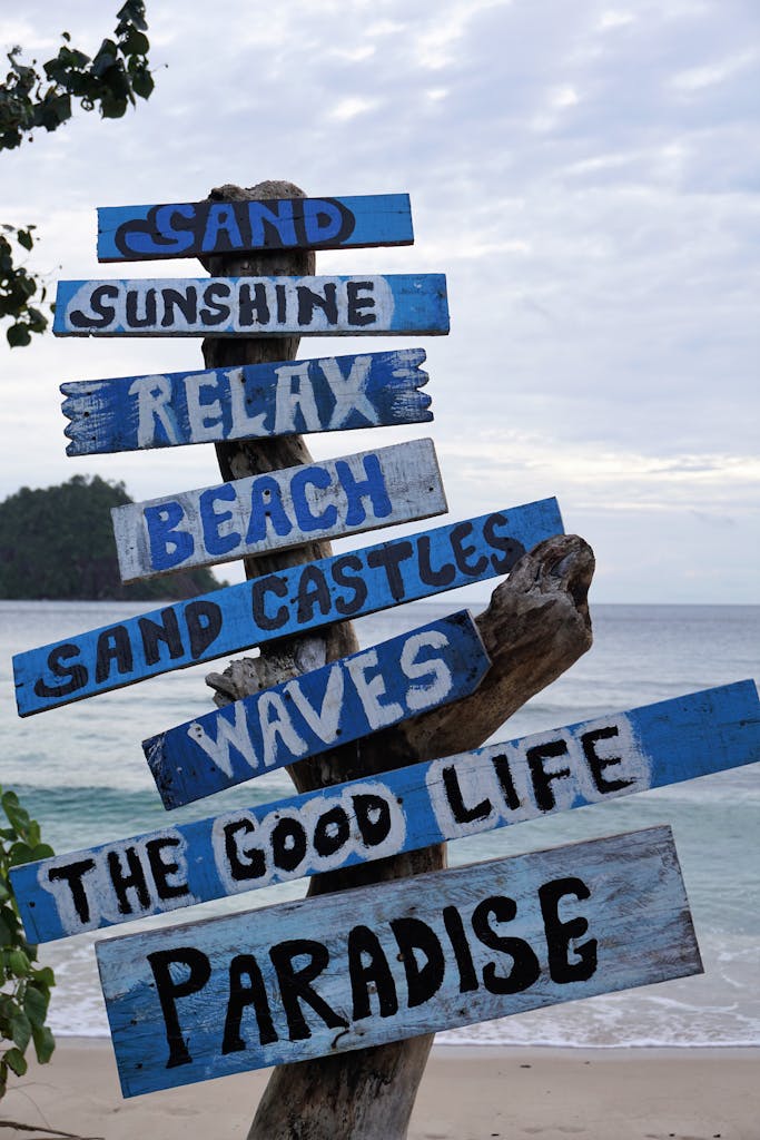Vibrant wooden beach signs promoting relaxation and paradise by the Indonesian shore.
